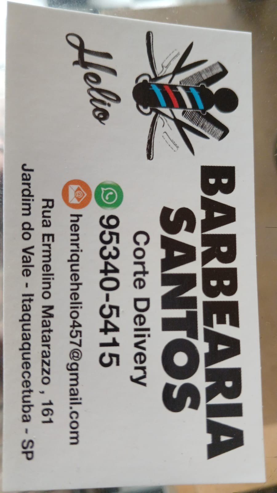 cartão de visita da Barbearia Santos com ilustração de poste de barbeiro, navalhas e pentes, fundo branco